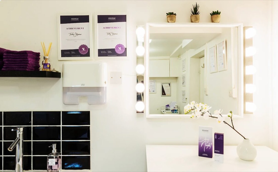 Training certificates on the treatment room wall beside the mirror